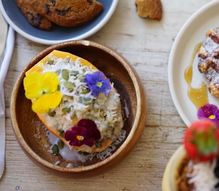 Chilled Coconut Quinoa Porridge wrapped within a fresh Papaya boat.