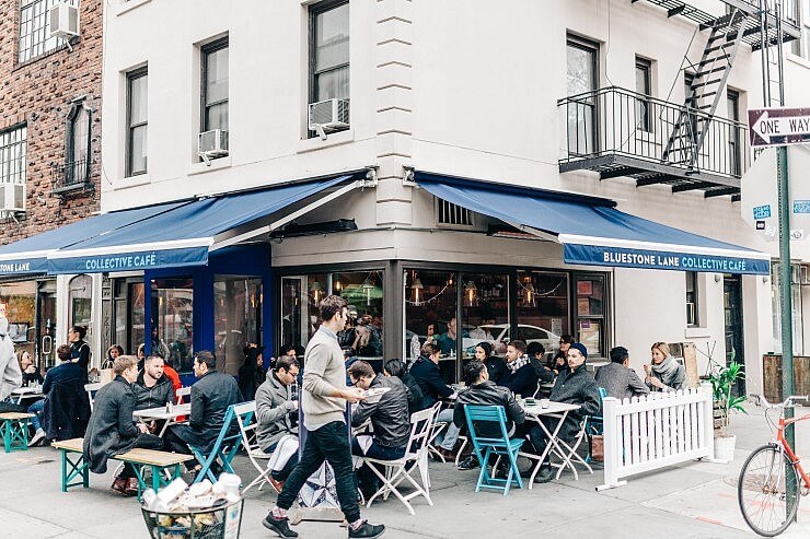 tables full of people sitting outside of Collective Cafe. 