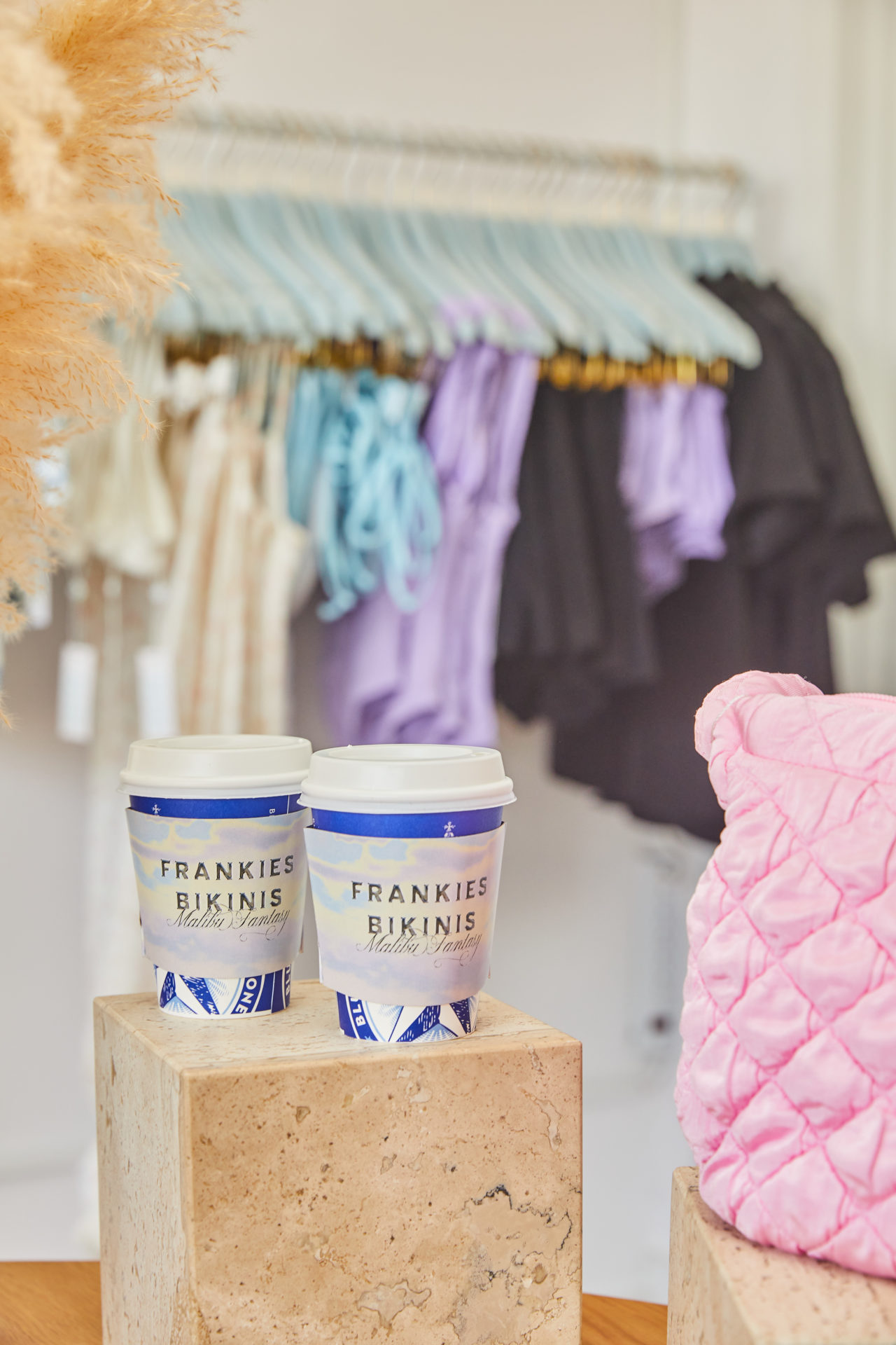 Frankie's Bikini store, two Bluestone Lane coffee cups with Frankies Bikinis sleeves