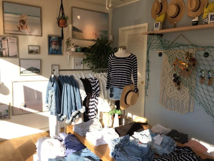 Bluestone Lane retail space in the Montauk store with clothing racks filled with cotton-on clothing. 