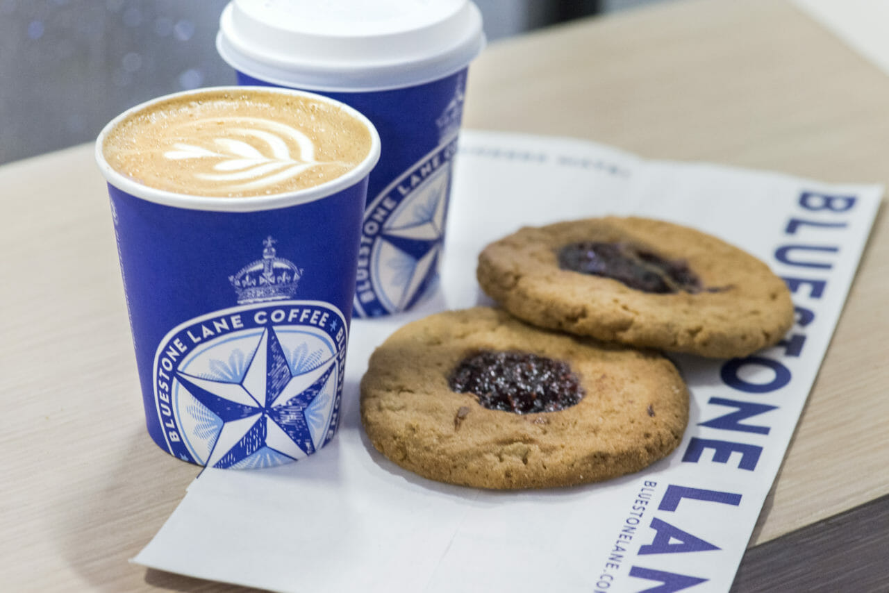 latte in a bluestone lane cup and jam drop cookies.