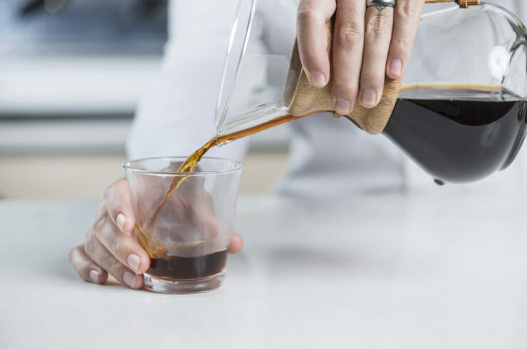 pouring the chemex brewed coffee into a glass. 