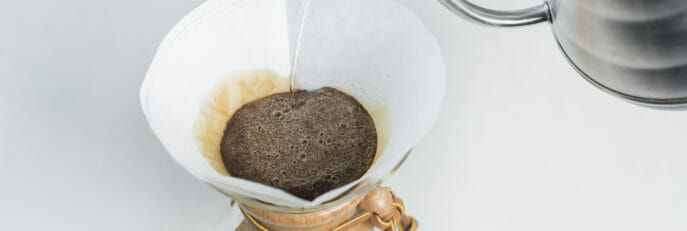 Water being poured over coffee grinds into the Chemex.