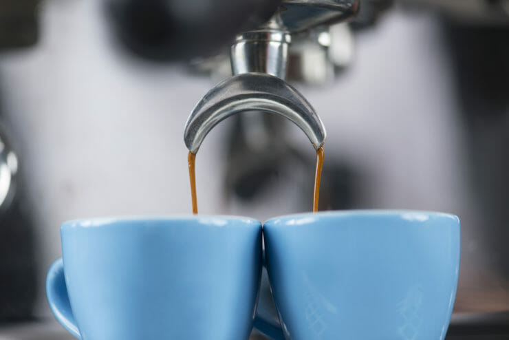 espresso coming out of machine and into two espresso cups. 