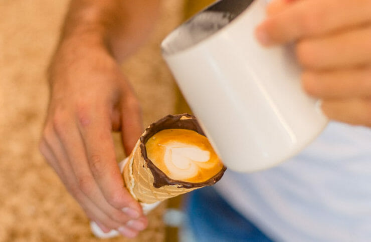 Barista pouring milk into the BL Coffee in a Cone. 