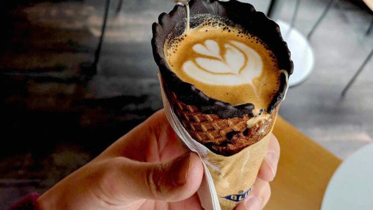 Waffle cone with tulip latte art poured into it.