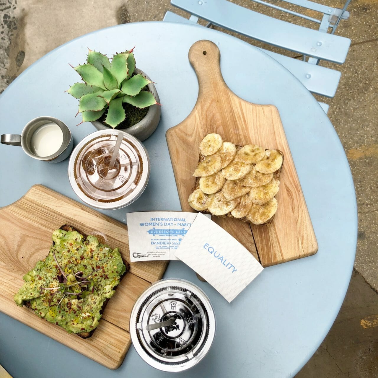 Aerial shot of equality coffee sleeves on table with Bluestone Cold brew and Toasts