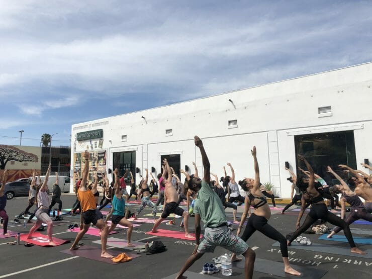 Crowd of 40 people doing yoga outdoors.