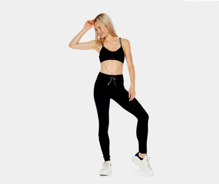 Woman wearing black workout pants and top by The Upside.