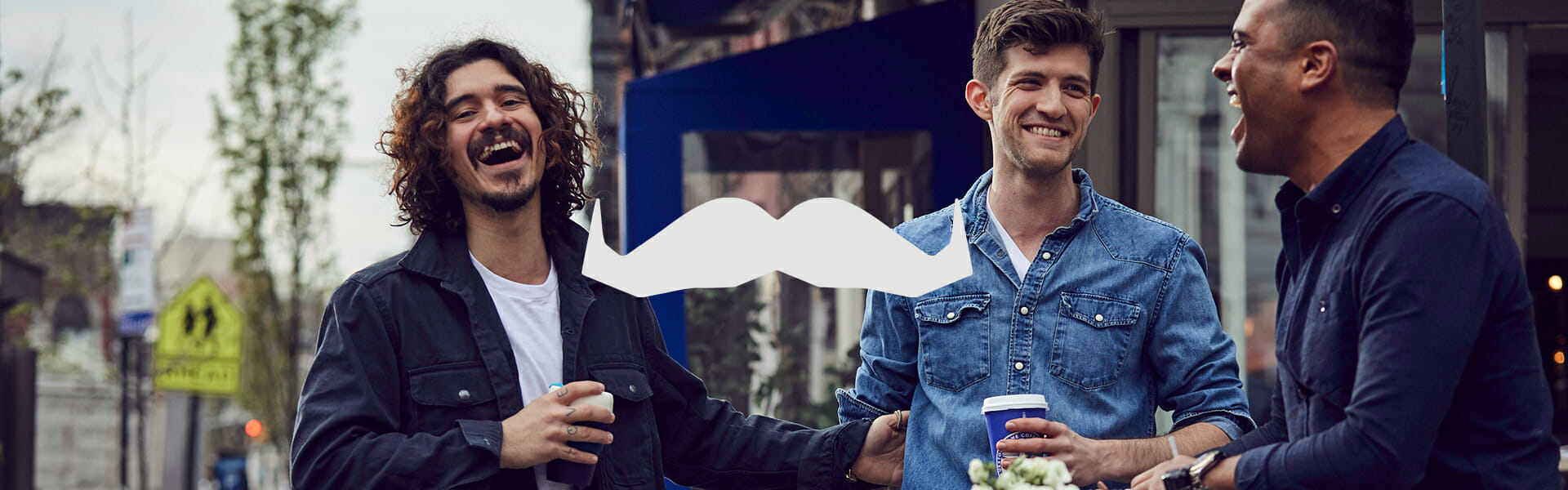 Two men standing outside drinking Bluestone Lane coffee.