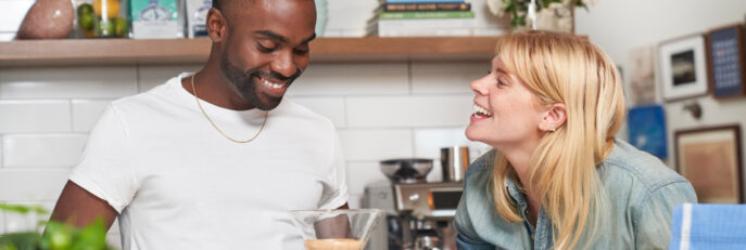 Two people smiling at each other in a kitchen