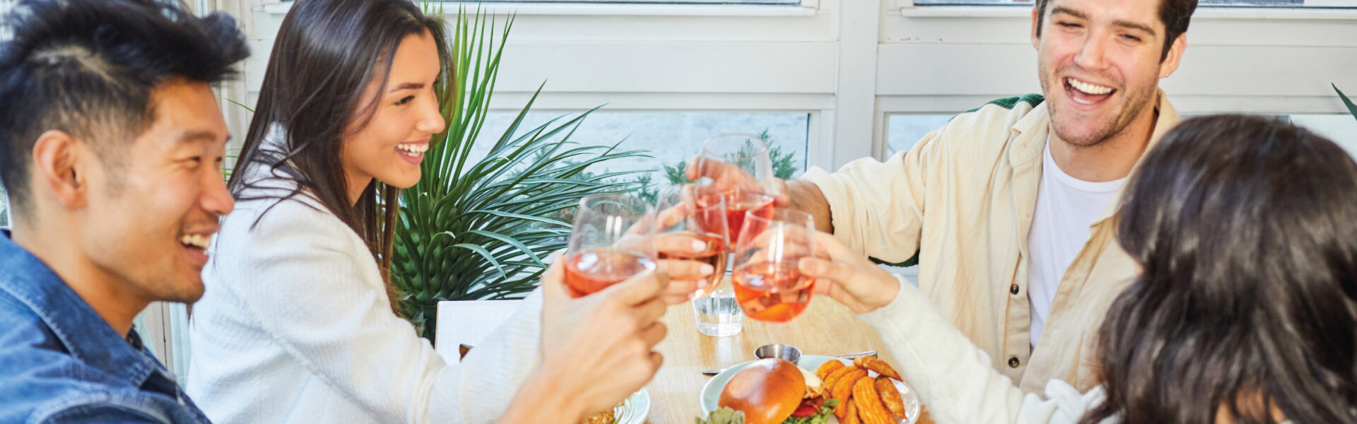 A group of friends cheers Aperol Spritz at a café